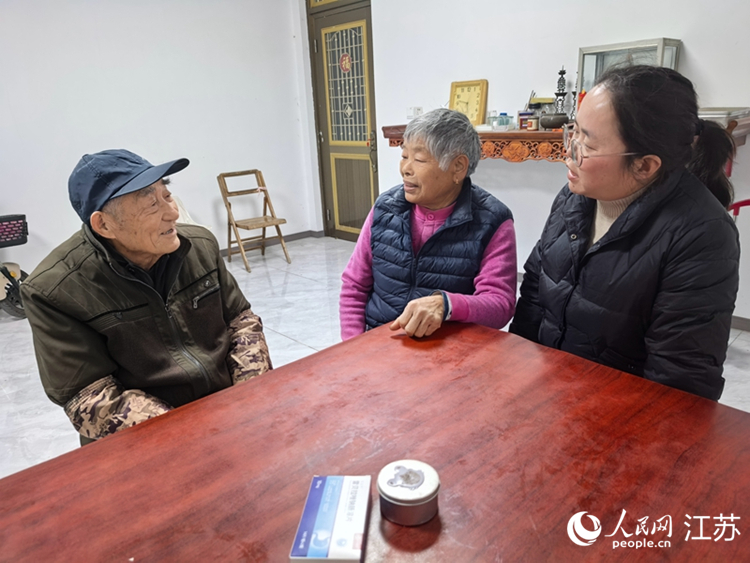 张玉芳（中）上门看望九旬老人熊志华。人民网记者 王继亮摄