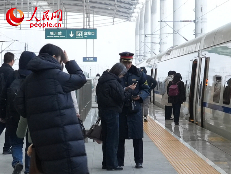 1月4日,银川火车站工作人员正在帮助旅客核对乘车信息。人民网记者 梁宏鑫摄