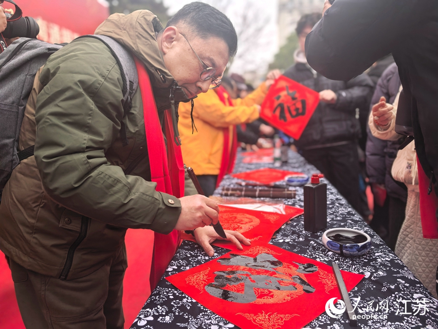 崇川区书法家协会副主席李暘现场为市民写福字。人民网记者 王继亮摄