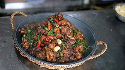 “炒鸡一条街”为啥吃得香？临近中午，不远处的磨石塘村，“炒鸡一条街”香味四溢。这条两三百米长的石板老街上，密集开着10家炒鸡店。“脚掌厚、脚垫硬，一看就是做炒鸡的好材料。”“磨堂人家”店主王敏拎起一只现宰鲜鸡说。