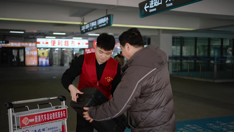 志愿者帮助旅客搬运行李。