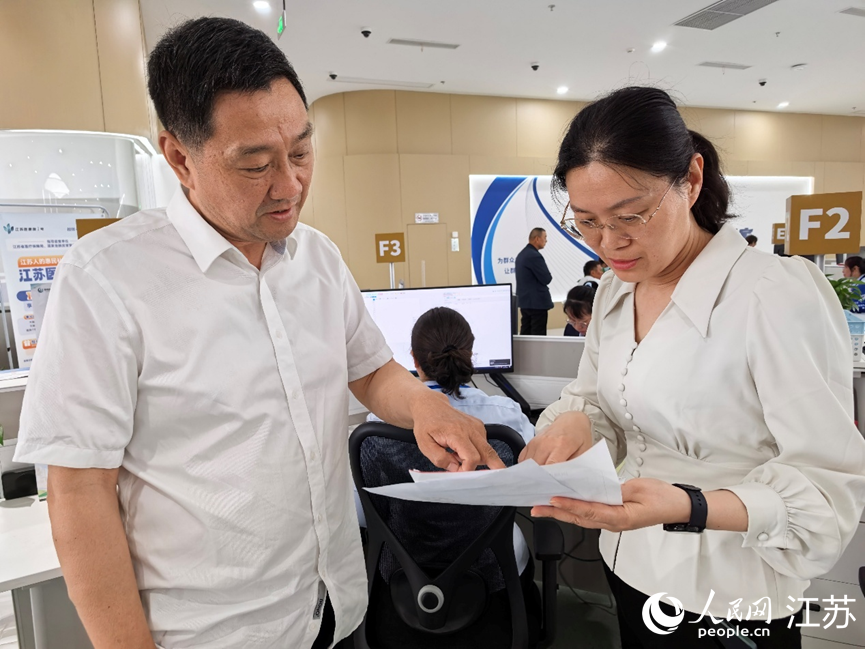 海安市醫保局副局長陸曉靜（右）協助群眾辦理醫保報銷。人民網記者 王繼亮攝