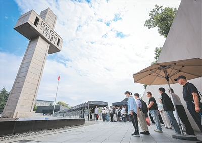 在侵華日軍南京大屠殺遇難同胞紀念館，人們在防空警報聲中肅立默哀。蘇 陽攝（新華社發）