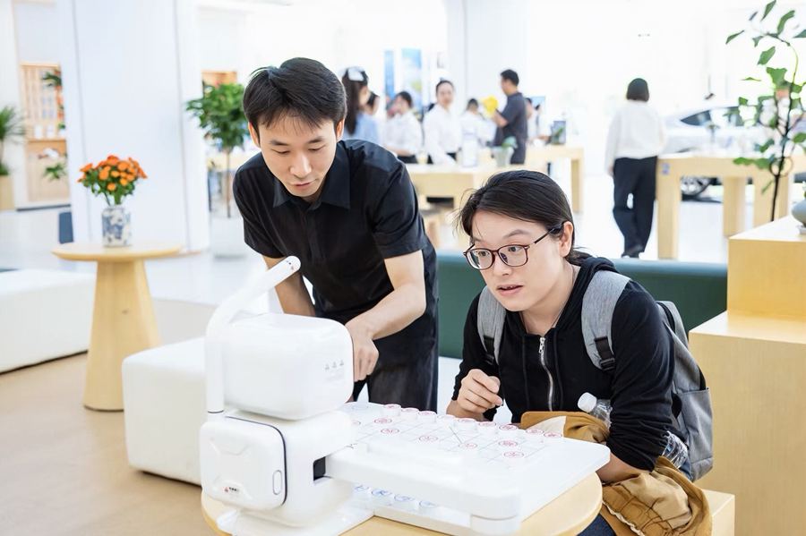 市民走進泰州移動服務廳內的數智體驗區與 AI 下棋機器人人機對弈。江蘇移動供圖