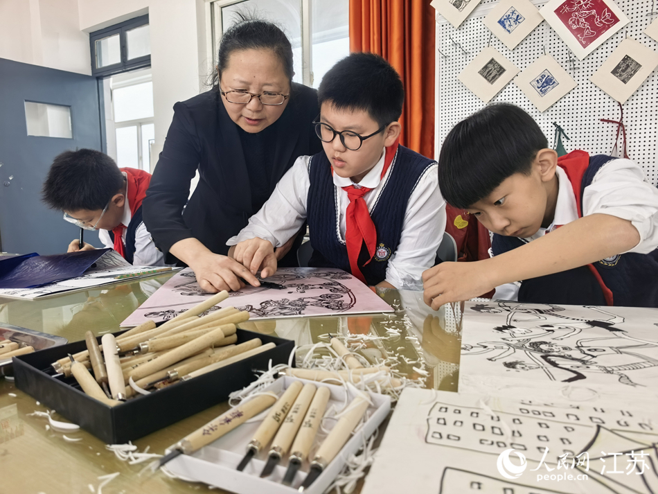 东海县实验小学老师指导学生版画创作。 人民网记者 张玉峰摄