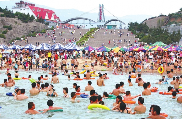 游人在连岛大沙湾游乐园“闹海”消暑