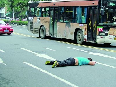 南京醉酒男大街撒泼被拘 横卧路上见人就打