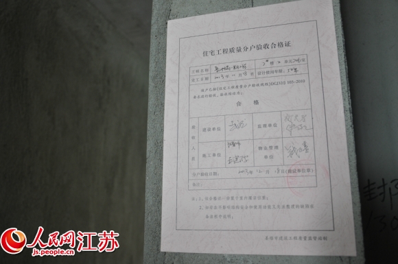 开发商自制的"住宅工程质量分户验收合格证"贴在房内