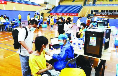 8月24日，在南京师范大学仙林校区体育馆疫苗临时接种点，学生在家长陪同下接种新冠疫苗。通讯员 李欣 南报融媒体记者 崔晓 徐琦摄 