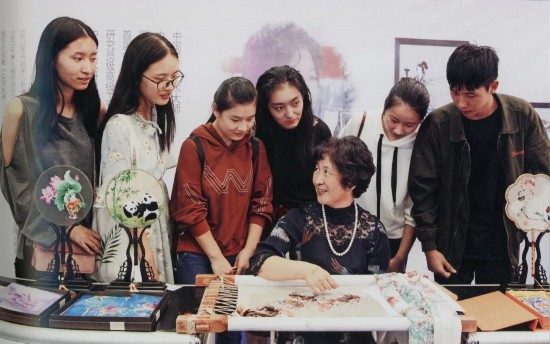 图为国家级非遗传承人向江南大学大学生们讲授苏绣的技艺。