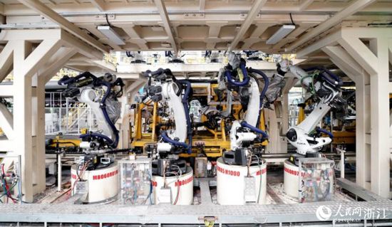 “未來工廠”全自動化焊接車間內多台機械臂正在運作。人民網 陳陸洵攝