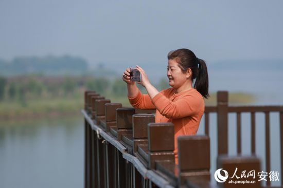 “三姑娘”陳蘭香在薛家窪記錄江邊美景。人民網記者 張俊攝
