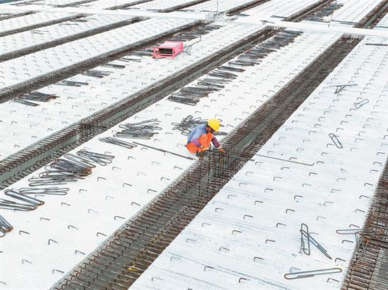 一名工人在北環路高架施工路面上鋪設鋼筋。