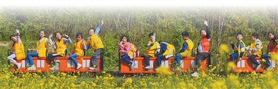 重慶市北碚區歇馬街道虎頭村，青少年們乘坐小火車感受鄉村田園之美，樂享春日假期。秦廷富攝
