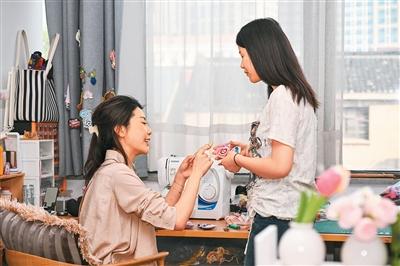 吴澄（左）与同事一同探讨文创产品开发。徐 洋摄